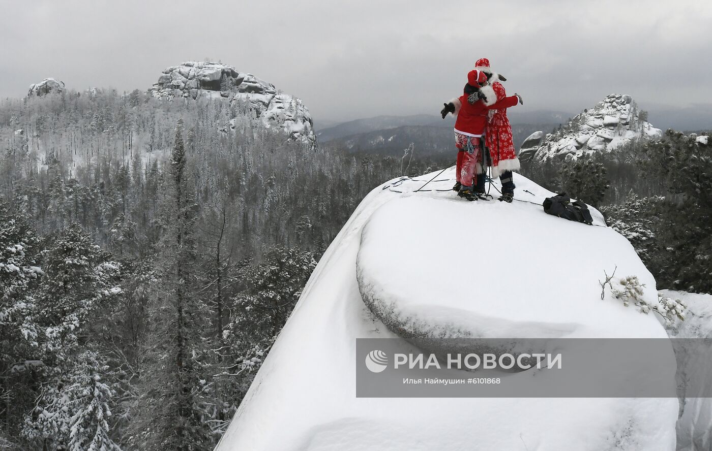 Члены поисково-спасательного отряда КГКУ "Спасатель" Дмитрий Иванов в костюме Деда Мороза (справа) и Михаил Морин в костюме Санта Клауса участвуют в заключительной скальной тренировке года на сиенитовой скале "Четвертый Столб" в национальном парке "Столбы" в Красноярском крае. Место: Россия, Красноярск. Автор: Илья Наймушин/РИА Новости. Работа отряда "Спасатель" в Красноярске