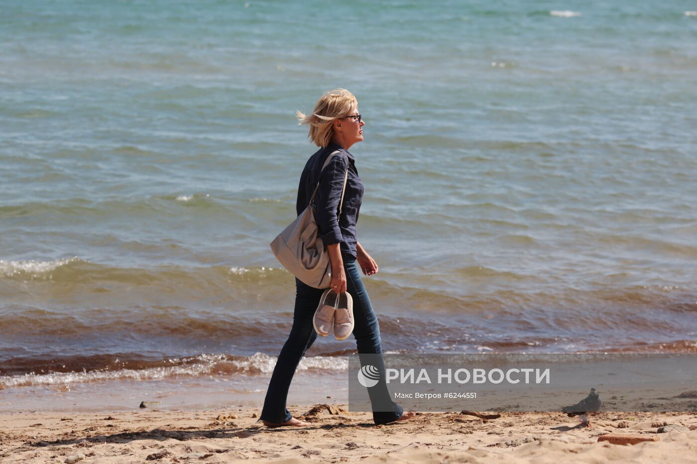 Женщина идет по пляжу в Евпатории. В Крыму с 18 мая отменяется режим самоизоляции. Место: Россия, Евпатория. Автор: Макс Ветров/РИА Новости. Ослабление карантинного режима в городах России