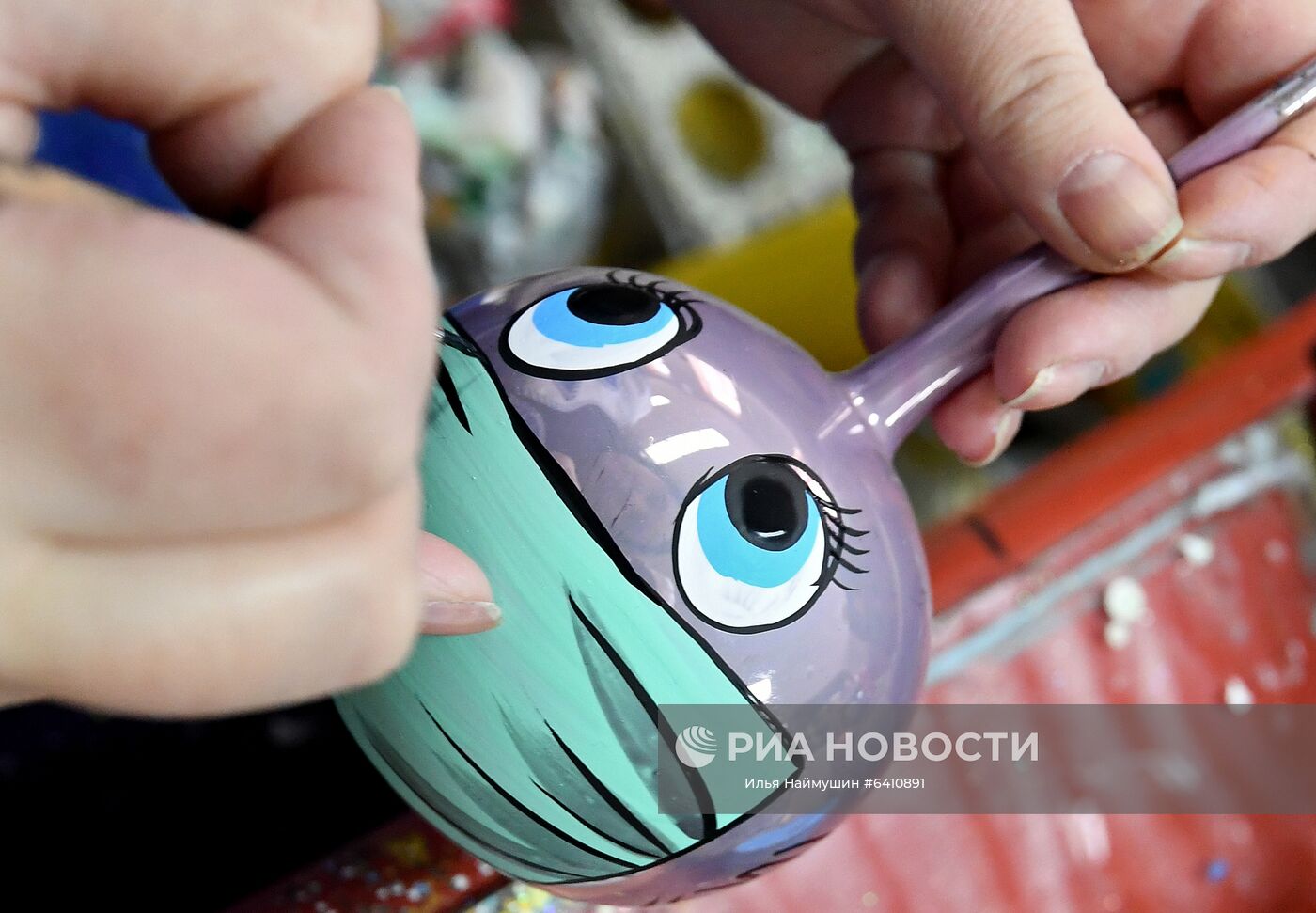 Художница расписывает стеклянный новогодний шар на фабрике игрушек "Бирюсинка" в Красноярске. Повышенным спросом у покупателей в этом году пользуются ёлочные украшения с изображением защитных лицевых масок. Место: Россия, Красноярск. Автор: Илья Наймушин/РИА Новости. Красноярская фабрика игрушек выпустила елочные шары в масках от COVID-19