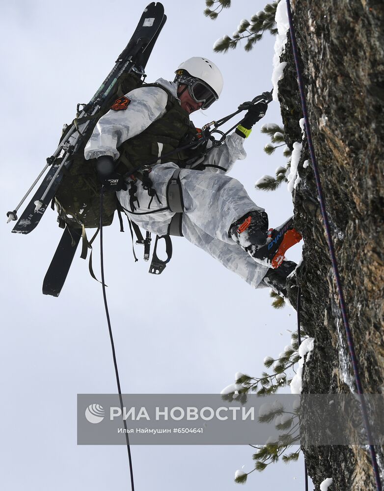 Участник лыжного марш-броска всеармейского конкурса по ски-альпинизму "Саянский марш" выполняет спуск по закрепленной веревке на скальном спецучастке в горах Западных Саян на юге Красноярского края. Место: Россия, Красноярский край. Автор: Илья Наймушин/РИА Новости. Всеармейский конкурс по ски-альпинизму "Саянский марш" в Красноярском крае