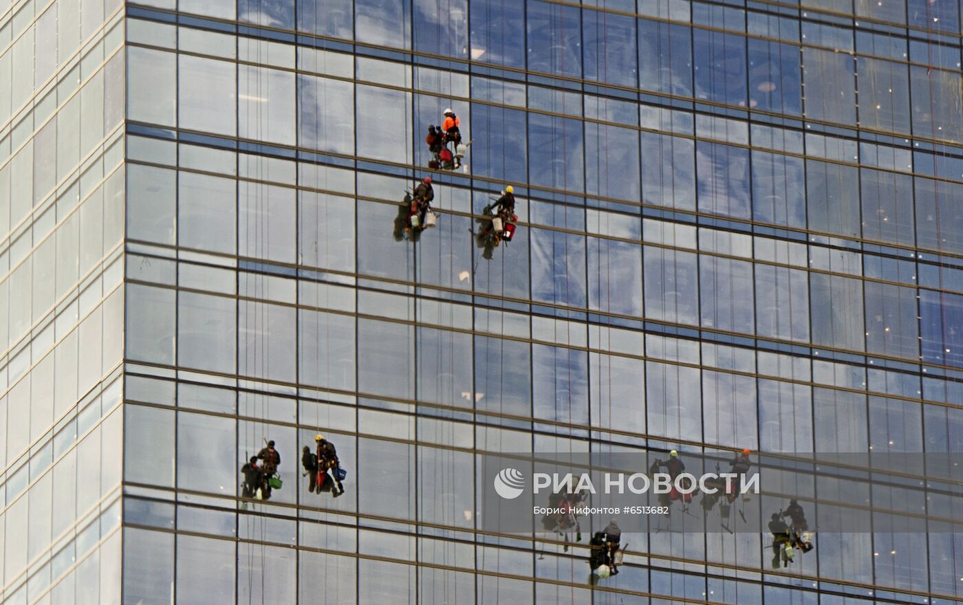 Промышленные альпинисты моют фасад здания бизнес-центра 