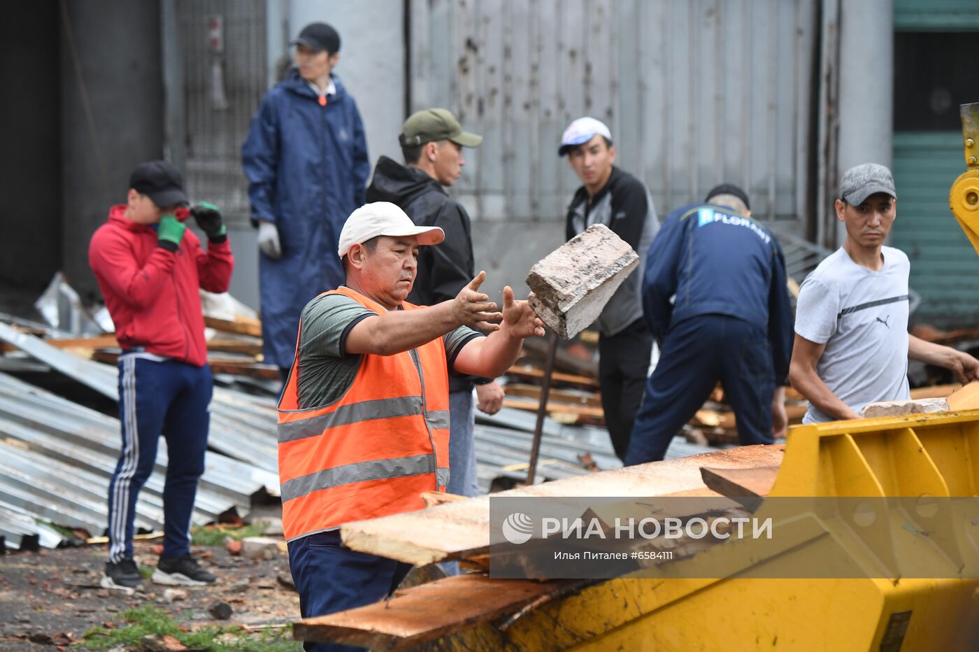 Сотрудники коммунальных служб ликвидируют последствия обрушения из-за сильного ветра во время дождя части крыши здания на улице Правды в Москве. Место: Россия, Москва. Автор: Илья Питалев/РИА Новости. Дождь в Москве