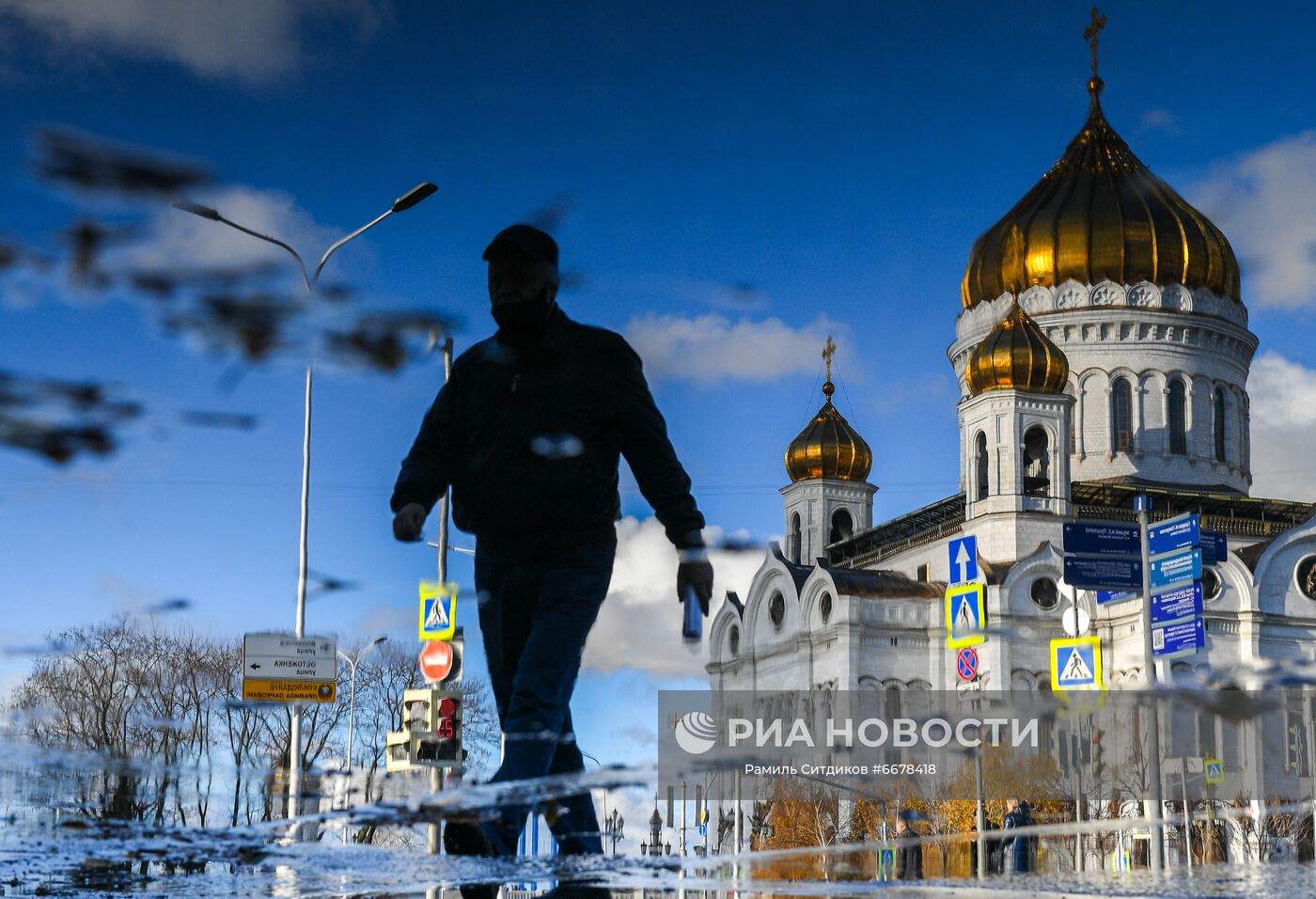 Отражение в луже прохожего и храма Христа Спасителя. Место: Россия, Москва. Автор: Рамиль Ситдиков/РИА Новости. Повседневная жизнь