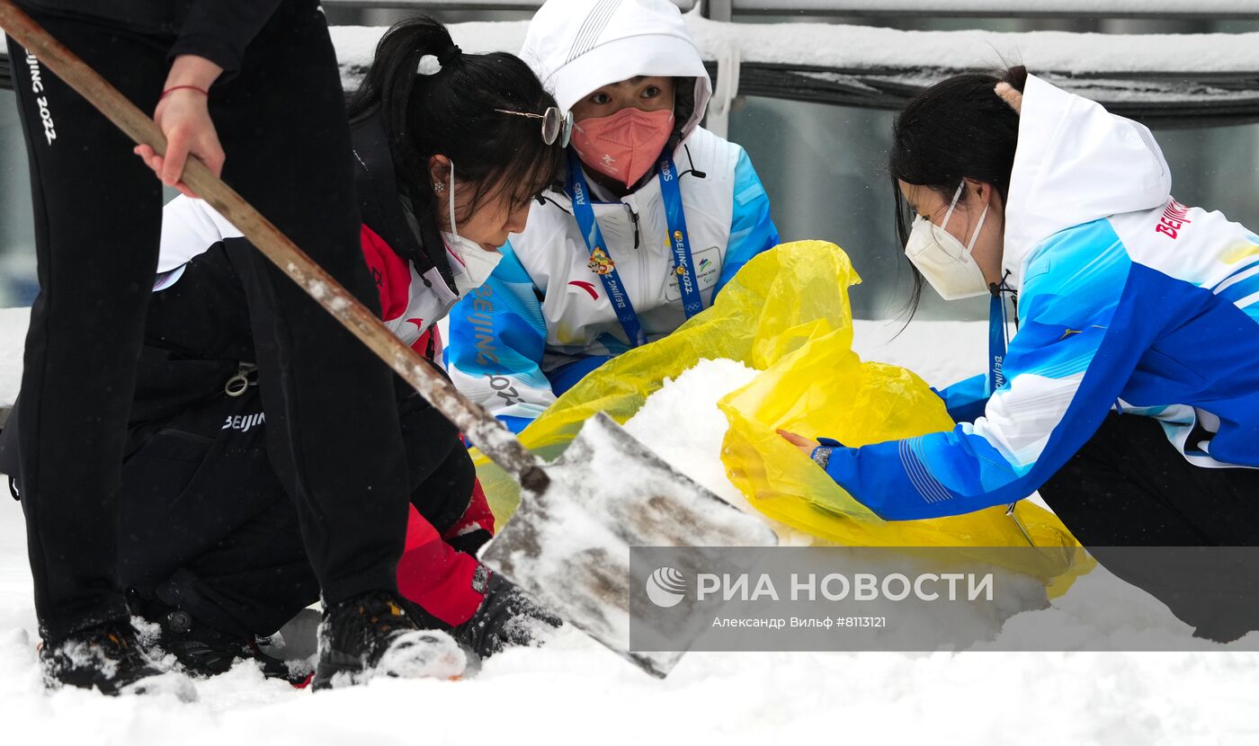 Волонтеры лепят снеговика у здания главного пресс-центра XXIV Олимпийских игр в Пекине. Место: Китай, Пекин. Автор: Александр Вильф/РИА Новости. Снегопад в олимпийском Пекине