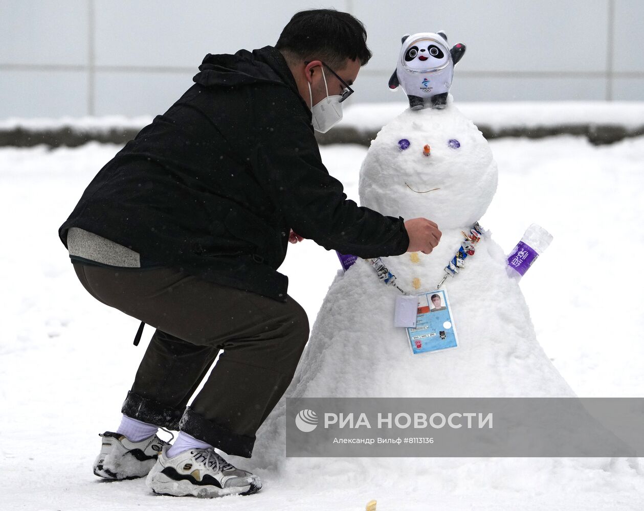 Мужчина лепит снеговика у здания главного пресс-центра XXIV Олимпийских игр в Пекине. Место: Китай, Пекин. Автор: Александр Вильф/РИА Новости. Снегопад в олимпийском Пекине