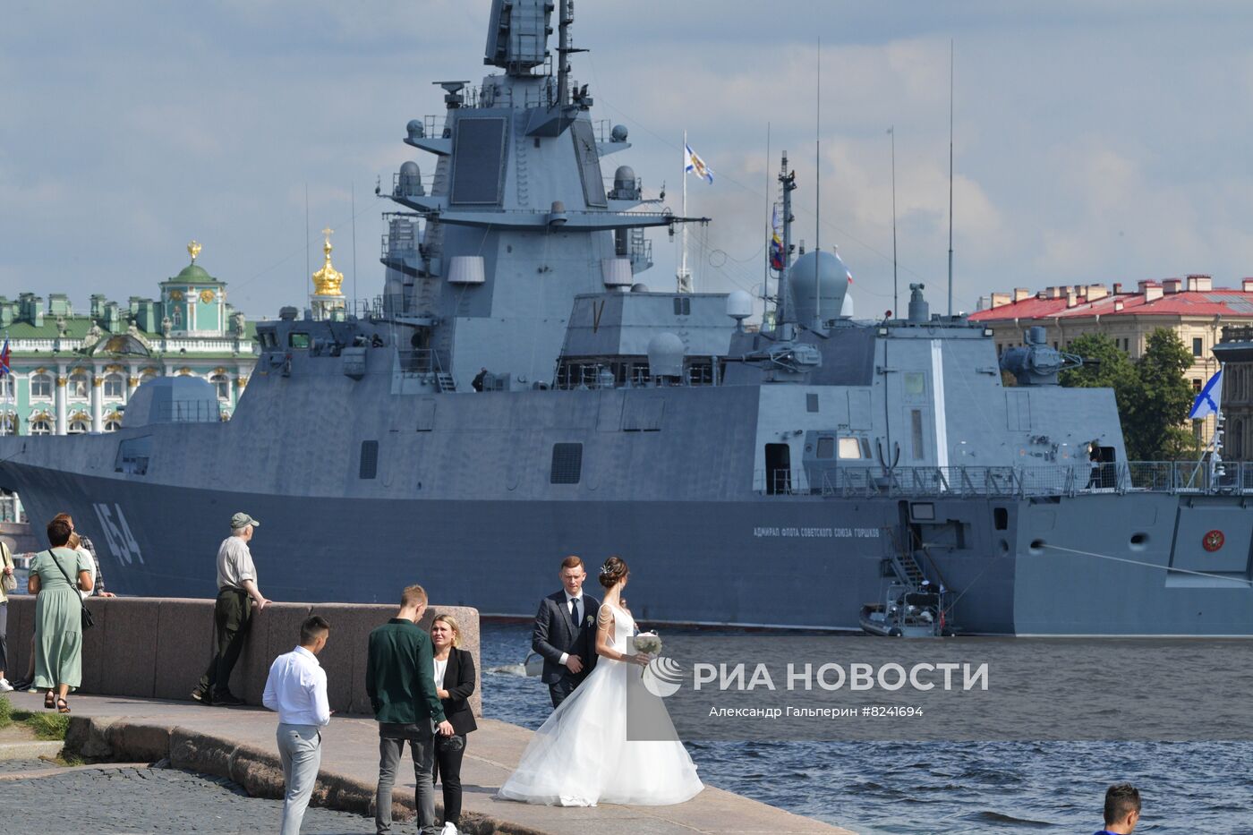 Молодожены на набережной в Санкт-Петербурге. На втором плане: фрегат проекта 22350 "Адмирал флота Советского Союза Горшков", прибывший для участия в морском параде в День ВМФ. Место: Россия, Санкт-Петербург. Автор: Александр Гальперин/РИА Новости. Репетиция парада ко Дню ВМФ в Санкт-Петербурге