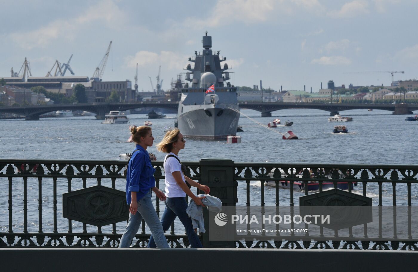 Прохожие на мосту в Санкт-Петербурге. На втором плане: фрегат проекта 22350 "Адмирал флота Советского Союза Горшков" в акватории реки Невы после репетиции морского парада ко Дню ВМФ. Место: Россия, Санкт-Петербург. Автор: Александр Гальперин/РИА Новости. Репетиция парада ко Дню ВМФ в Санкт-Петербурге