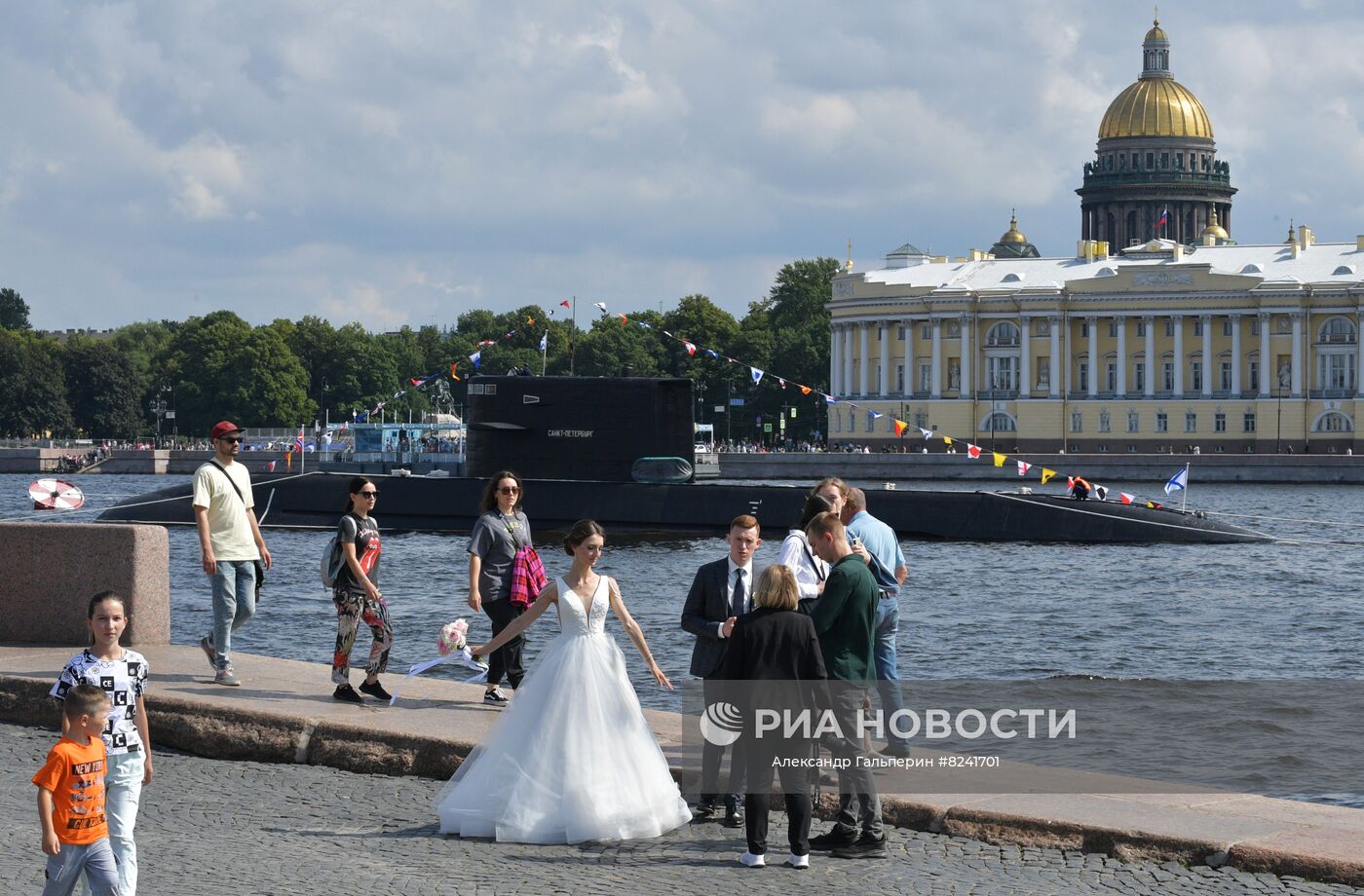 Молодожены на набережной в Санкт-Петербурге. На втором плане: дизель-электрическая подводная лодка Б-585 "Санкт-Петербург" в акватории реки Невы после репетиции морского парада ко Дню ВМФ. Место: Россия, Санкт-Петербург. Автор: Александр Гальперин/РИА Новости. Репетиция парада ко Дню ВМФ в Санкт-Петербурге