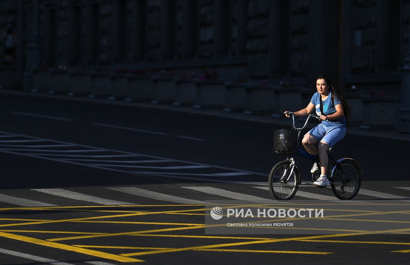 Женщина на велосипеде едет по пешеходному переходу