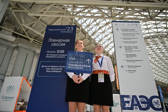 Волонтеры держат указатели к площадке проведения пленарного заседания Евразийского экономического форума на территории Парка науки и искусства "Сириус". Место: Россия, Федеральная территория "Сириус". Автор: Рамиль Ситдиков/РИА Новости. ЕАЭС-2023. Работа форума