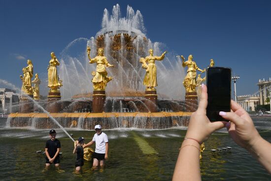 Москвичи и туристы в жаркую погоду в Москве