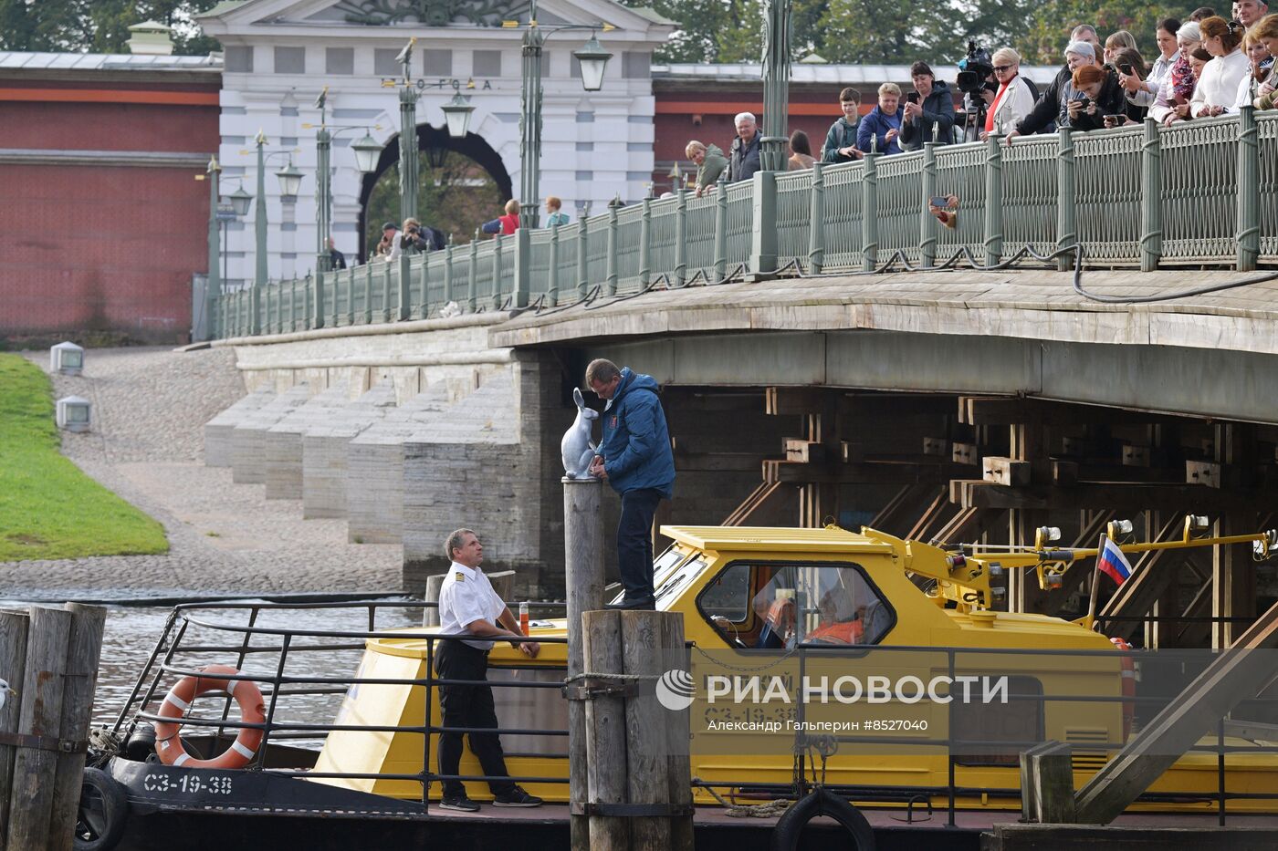 Возвращение памятника зайцу Арсению после реставрации к Петропавловской крепости в Петербурге