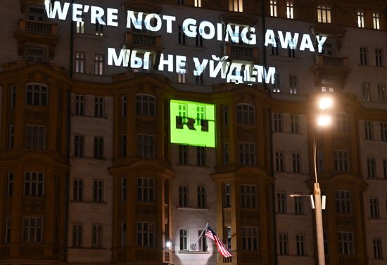 Видеопроекция RT "Were not going away. Мы не уйдем" на здании посольства США в Москве